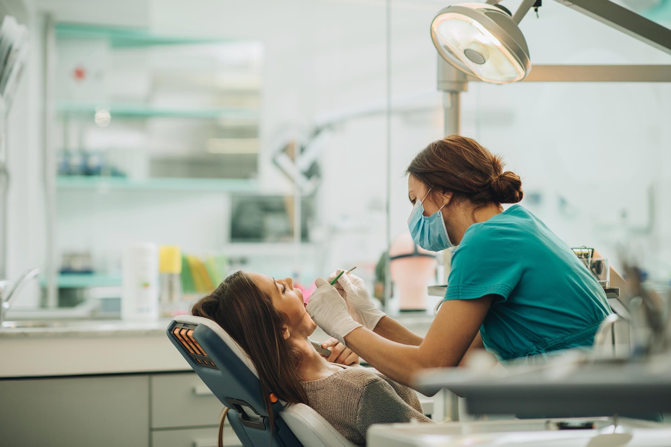 A dental hygienist examining a relaxed patient in a modern clinic