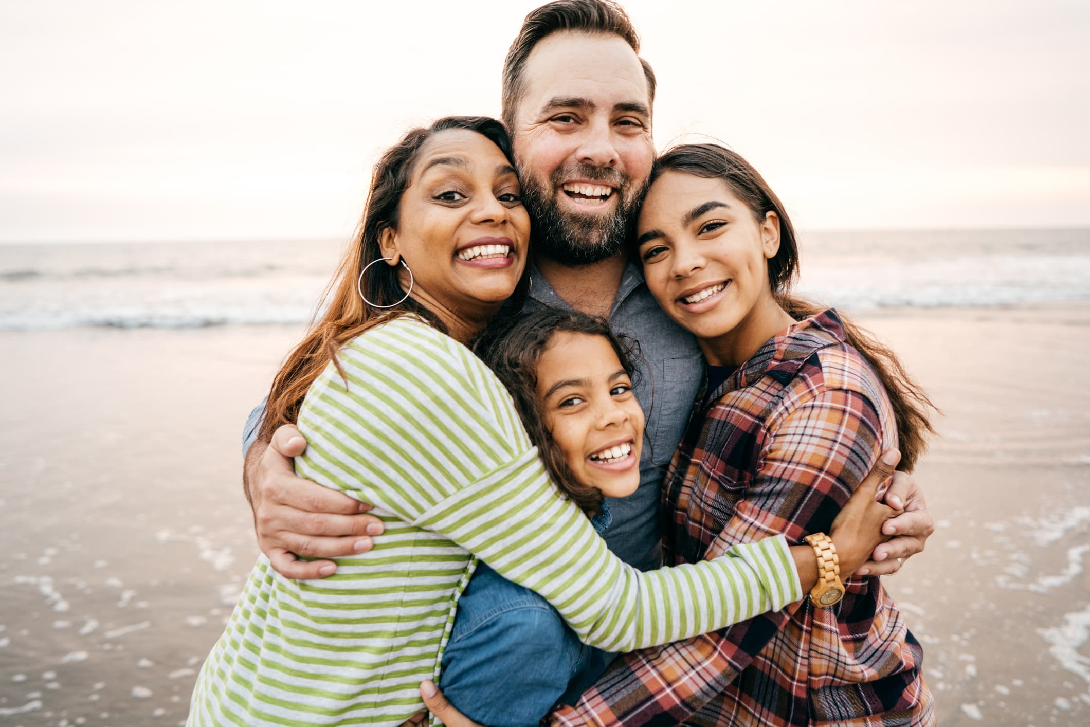 A multigenerational family embracing and smiling together
